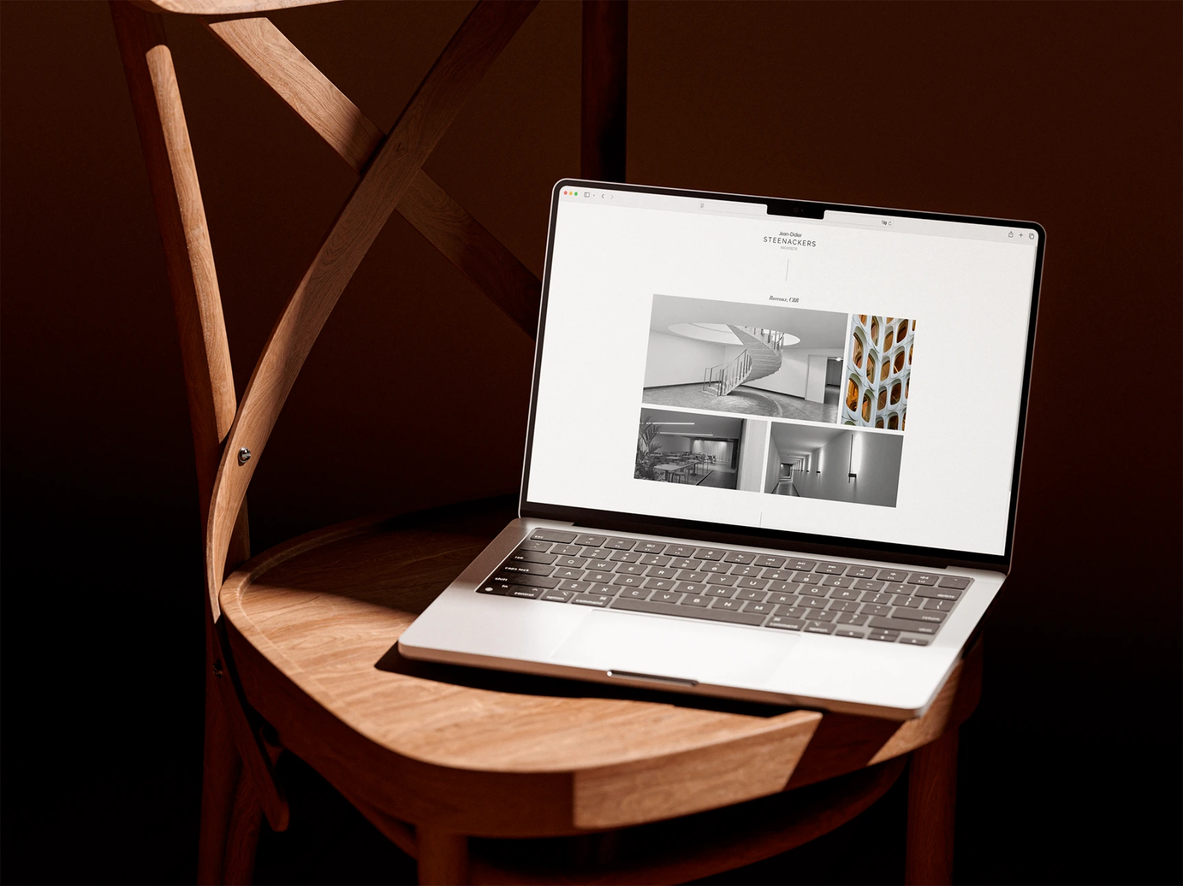 Architect’s website displayed on a MacBook placed on a designer chair.